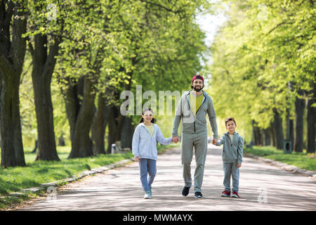 Père tenant la main de son fils et sa fille et walking in park Banque D'Images