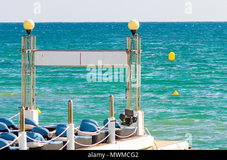 Transats sur la jetée avec l'eau bleue turquoise à l'avant Banque D'Images