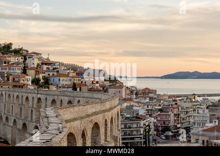 Voir en haut de l'aqueduc jusqu'au milieu de la vieille ville de Kavala, Grèce, à l'ensemble des toits vers la mer au coucher du soleil d'or Banque D'Images