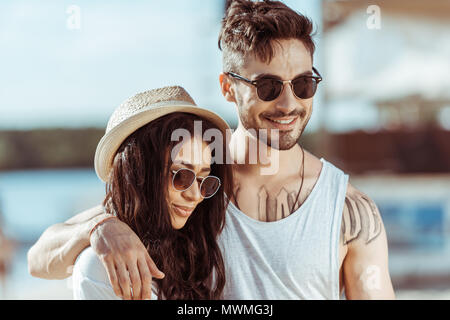 Heureux couple interracial dans lunettes hugging et passer du temps ensemble Banque D'Images