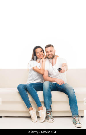 'Portrait de jeune beau couple regardant la tv avec la commande à distance, isolated on white Banque D'Images