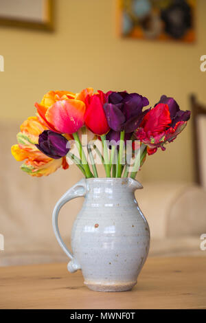 Un thème rouge Tulip arrangement dans un pot en céramique gris. Doté d''Tulipa 'Rococo', Tulipa 'Sunlover', 'Queensday Tulipa Tulipa' et 'Purple Flag' Banque D'Images