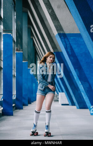 Jeune femme à la mode de vêtements en jean et chaussettes de roller seul Banque D'Images