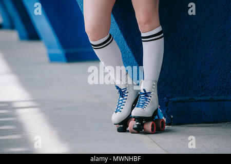 Vue partielle de la femme en blanc chaussettes et patins à roulettes rétro Banque D'Images