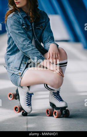 Vue partielle de l'élégant femme en denim vêtements, chaussettes et patins à roulettes rétro Banque D'Images