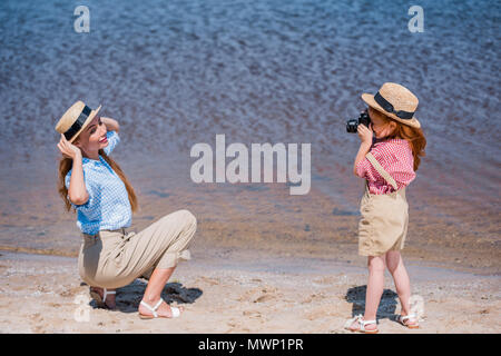 Adorable petite fille photographier près de la mer mère heureuse Banque D'Images