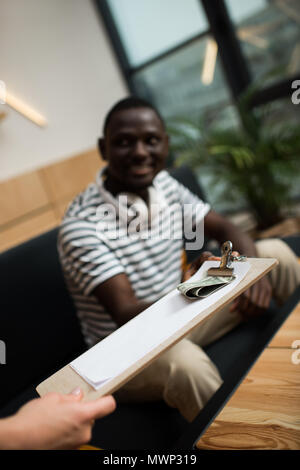 Cropped shot of african american man looking at waiter holding bill avec de l'argent dans le Banque D'Images