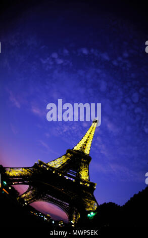 La Tour Eiffel, à au nord-ouest vers le bas du Champ de Mars et jusqu'au crépuscule, représentant d'éclairage sur une avec peu de nuages moelleux et twilight glow, Paris, France Banque D'Images