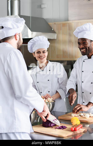 Équipe de chefs smiling multiraciale et la cuisine sur cuisine moderne Banque D'Images