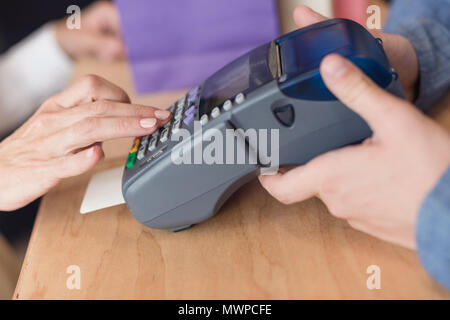 Cropped shot of woman making paiement par carte de crédit en magasin