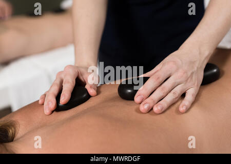 Cropped shot of woman having massage aux pierres chaudes au spa salon Banque D'Images