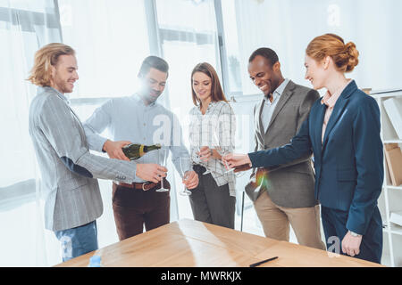 Dans l'homme shirt pouring champagne verres à Banque D'Images