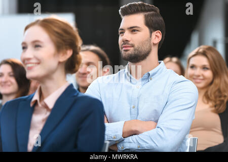 Man in blue shirt looking away while sitting at meeting Banque D'Images