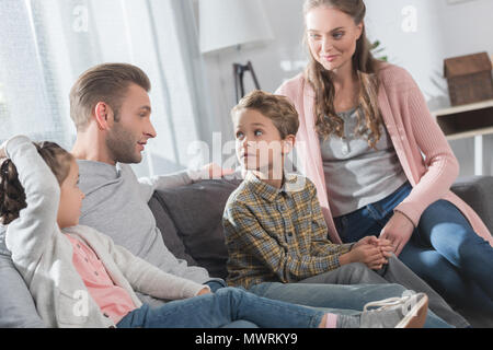 Papa assis sur table avec ses enfants et la femme tout en leur disant une histoire Banque D'Images