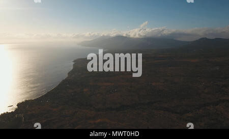 La côte de la mer au lever du soleil. Vue aérienne de lever de soleil sur la côte de l'océan, montagnes, mer, plage, Ciel, nuages. Bali, Lombok, Indonésie. Lever du soleil sur l'île de Bali Banque D'Images