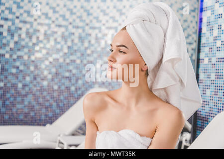 Thoughtful attractive woman with towel on head à spa Banque D'Images