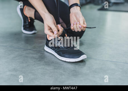 Cropped shot of woman lacage des sneakers avant la formation Banque D'Images