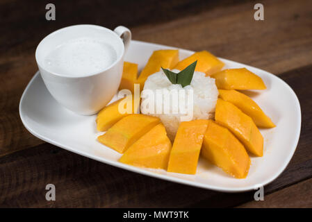 Mango sticky rice ou Khaoniao mamuang sur une table en bois, un dessert traditionnel thaïlandais à base de riz gluant,la mangue fraîche et lait de coco Banque D'Images