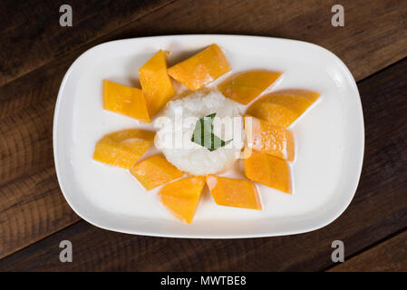 Mango sticky rice ou Khaoniao mamuang sur une table en bois, un dessert traditionnel thaïlandais à base de riz gluant,la mangue fraîche et lait de coco Banque D'Images