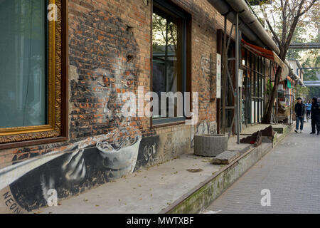 Young Girl eating noodles, graffitied sur un mur à la 798 Art Zone (Dashanzi Art District) à Beijing, Chine, Asie Banque D'Images