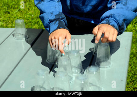 Des ados de comptage à la main des verres en plastique pour pique-niquer sur la table à l'extérieur, dans un jardin Banque D'Images