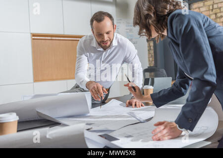 Architectes travaillant avec des plans de l'ensemble au bureau moderne Banque D'Images