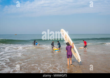 Surfez étudiant à obtenir dans de l'eau sur une plage de Goa, en Inde, au cours d'une session au début de l'été. Banque D'Images