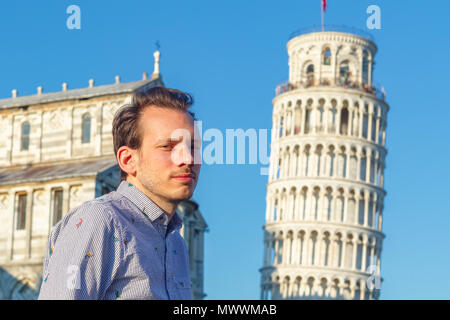 Un jeune blanc pose en face de la Tour Penchée de Pise, Italie Banque D'Images