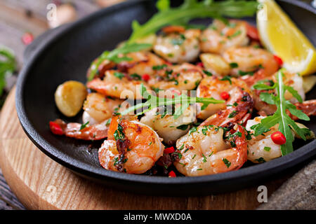 Crevettes Crevettes au beurre à l'ail rôti avec du citron et du persil sur fond de bois. Alimentation saine. Banque D'Images