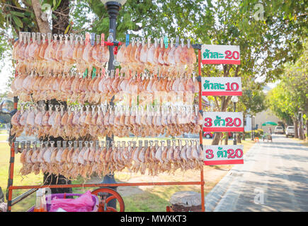 Rangée de calmar séché accroché à la ligne à la vente avec la police thaïlandaise Bangkok en Thaïlande. Banque D'Images