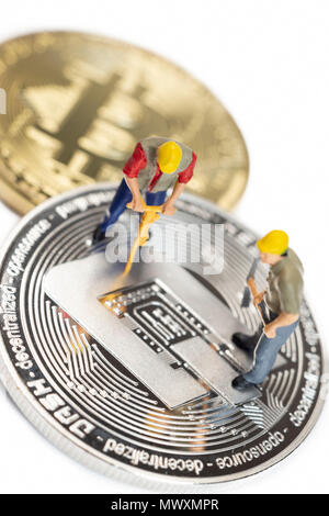 L'exploitation des travailleurs Cryptocoin miniature Dash sur une surface blanche Banque D'Images