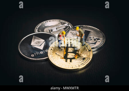 Les travailleurs de l'exploitation minière diverses Cryptocurrencies Miniature sur une surface noire Banque D'Images