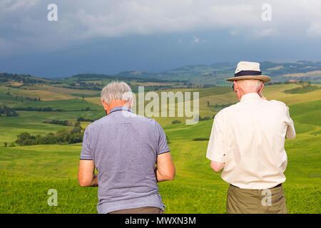 Deux hommes en admirant des vues sur San Quirico d'Orcia, près de Pienza, Toscane, Italie en mai Banque D'Images