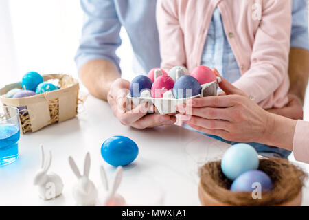 Le carton avec des œufs de Pâques dans les mains de la famille avec fille Banque D'Images