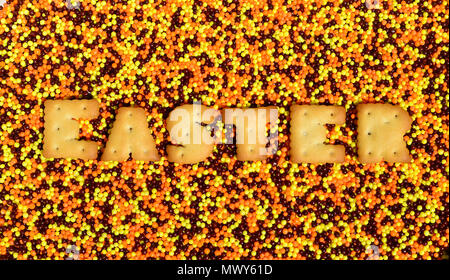 Pâques. Le mot de la cracker comestibles lettres se trouve sur le vitrage en poudre. Un nombre énorme de sucré, perles colorées de très petite taille pour la décoration Banque D'Images