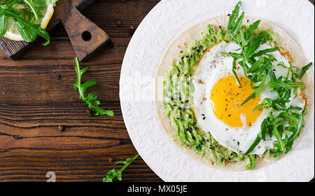 Les tacos de guacamole, œuf frit et la roquette. Alimentation saine. Petit-déjeuner utile. Mise à plat. Vue d'en haut Banque D'Images