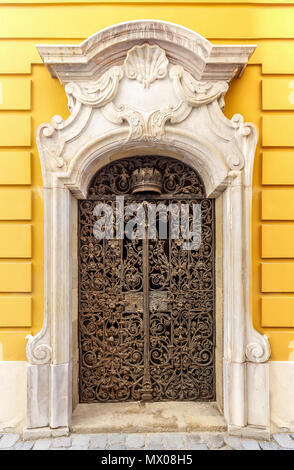 Arch metal porte dans un mur de l'église de plâtre jaune Banque D'Images