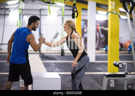 Jeune femme athlétique entraînement avec entraîneur personnel de sauter sur monter fort à la salle de sport Fitness Banque D'Images
