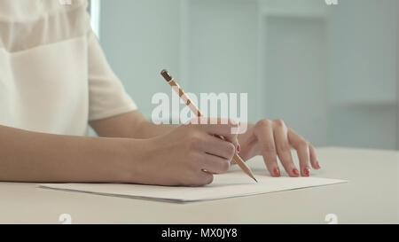 Femme avec crayon écrivant sur papier. Professional tourné en 4K de résolution. Vous pouvez l'utiliser par exemple dans une vidéo commerciale, d'affaires, présentation, broadcas Banque D'Images