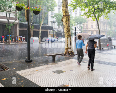 Les gens qui marchent avec des parapluies dans une tempête sur l'Avenida de Mayo dans le centre-ville, quartier Microcentro Montserrat dans capitale Buenos Aires, Argentine Banque D'Images