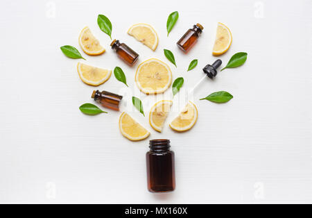 Flacon de médicaments avec des tranches de citron et de feuilles sur fond de bois blanc. Banque D'Images