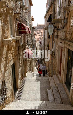 Vue vers le bas une rue typique à épaulement en flèche à l'intérieur des murs de la ville de la vieille ville de Dubrovnik, Croatie. Banque D'Images