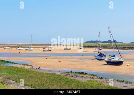 Marée basse dans l'estuaire au Wells-next-the-Sea. Les petits yachts s'asseoir à un angle a échoué sur le sable. Banque D'Images