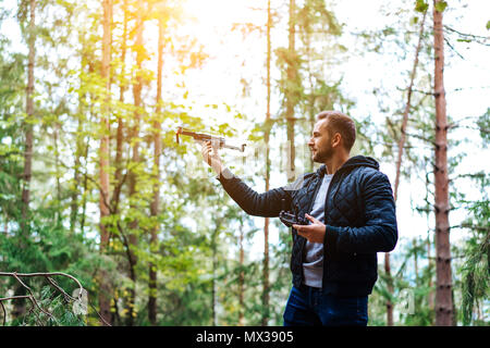 Guy démarre un quadrocopter dans la forêt Banque D'Images