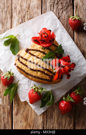 Délicieux gâteau éponge en forme de cœur, orné de roses Chocolat et Fraise close-up sur la table. Haut Vertical Vue de dessus Banque D'Images