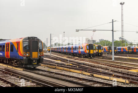 South Western Railway trains en bleu, rouge et jaune livery parqué dans des voies d'évitement à l'entrepôt à Clapham Junction Station, London, UK Banque D'Images