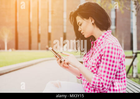 Jolie femme spontanée de l'écriture message sur téléphone. L'authenticité et de spontanéité. Conversation authentique au téléphone. L'Ecommerce. Banque D'Images