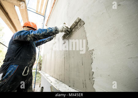 Travailler avec une spatule, la préparation des murs pour carrelage. Façade humide de la technologie. Banque D'Images