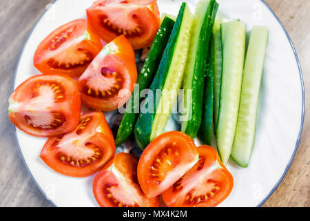 Tranches de tomates mûres et juteuses tranches de concombres sur la télévision de la plaque Vue de dessus vers le bas gros plan macro, table en bois comme collation santé ou salade apéritif Banque D'Images