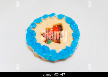 Décoré d'un vitrage avec givrage sucre candy sprinkles bleu artificiel coloré gros plan macro vacances de Noël biscuits maison au four, arbre isolé sur Banque D'Images